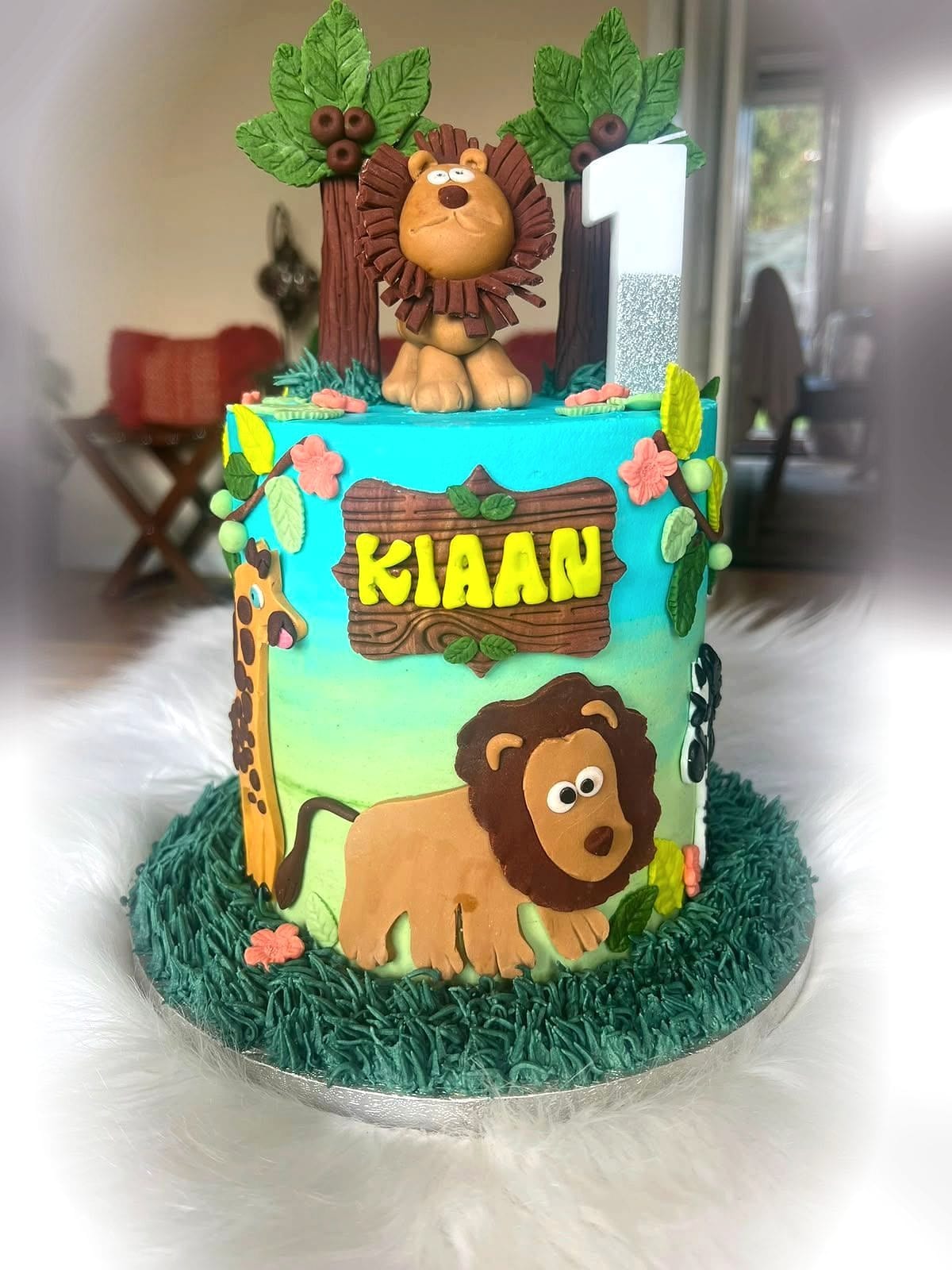 Jungle Safari First Birthday Cake by SpongyBakes — A safari cake with a hand-modelled lion, foliage and a piped grass base.